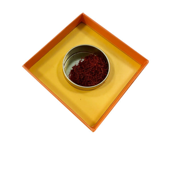 Small metal container with saffron in a decorative box on a white background